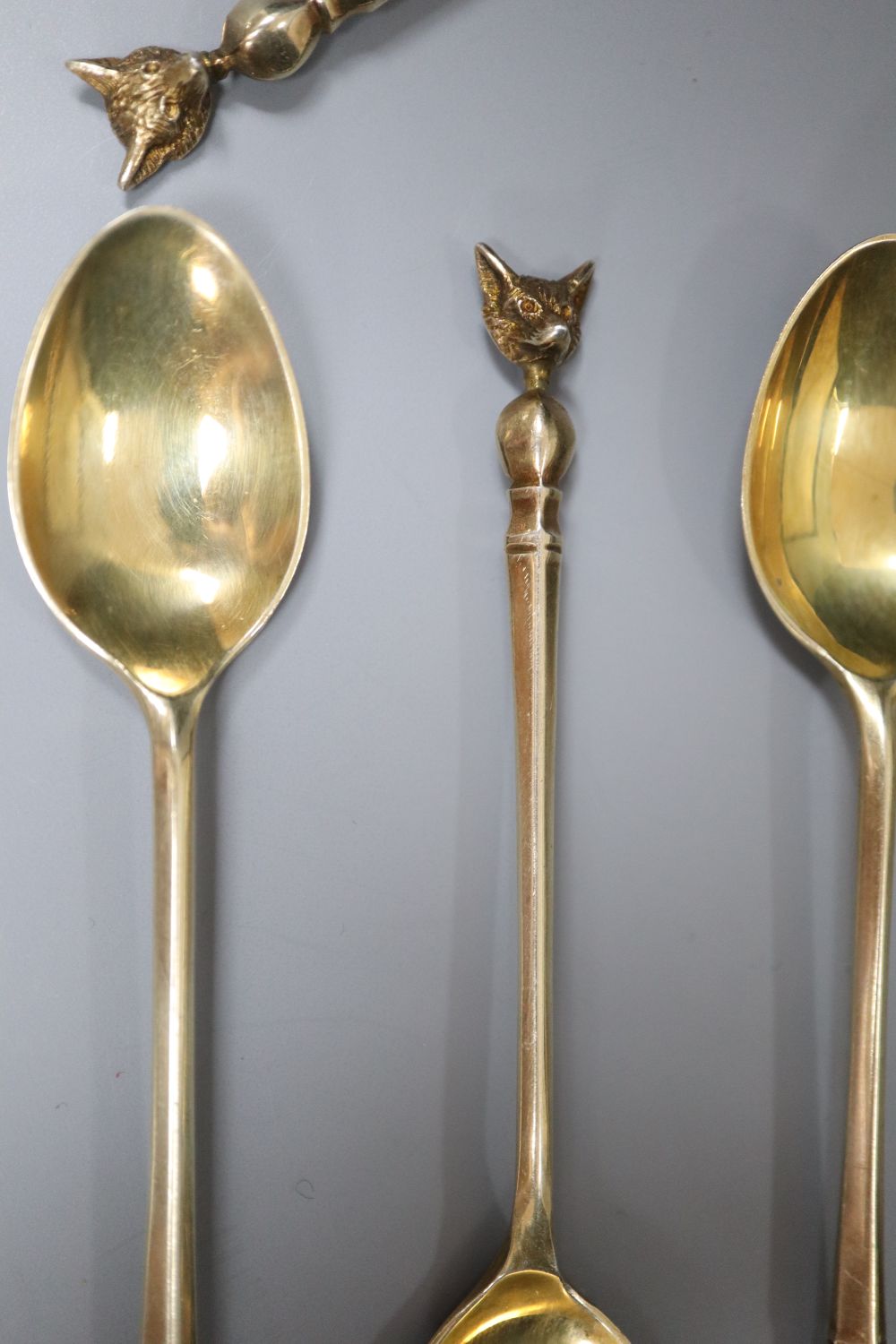 A set of six 1970s silver gilt fox head terminal coffee spoons, 77 grams and a plated set of coffee spoons.